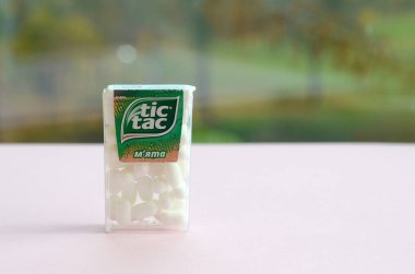 Yeşil ahşap arka planda bir sürü Tic Tac Candy paketi var. Tik tak naneli taze tadı ve taşıması kolay olduğu için popülerdir. 1968 'den beri Ferrero tarafından üretilen nane şekeri.