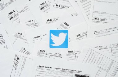 Birçok vergi formunda yazılı Twitter logosu yakın planda duruyor. Sosyal ağlardan internet ve bilgi kullanarak vergi sorunlarına yardım