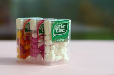 Yeşil ahşap arka planda bir sürü Tic Tac Candy paketi var. Tik tak naneli taze tadı ve taşıması kolay olduğu için popülerdir. 1968 'den beri Ferrero tarafından üretilen nane şekeri.
