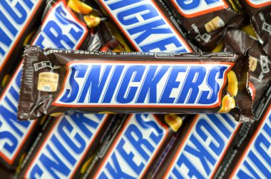 Bir sürü Snickers çikolatası üst üste yığılmış. Snickers çikolataları Mars Anonim Şirketi tarafından üretilir. Snickers 1930 yılında Franklin Clarence Mars tarafından yaratıldı.