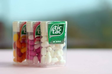 Yeşil ahşap arka planda bir sürü Tic Tac Candy paketi var. Tik tak naneli taze tadı ve taşıması kolay olduğu için popülerdir. 1968 'den beri Ferrero tarafından üretilen nane şekeri.