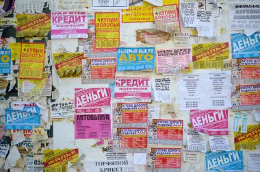 Kharkov, Ukrayna - 2 Ekim 2019: Grunge Mesaj Kurulu birçok reklamla birlikte. İnsanlar beyaz kağıda reklam ve bilgi yayıyorlar, metal çitlere asmaktansa.