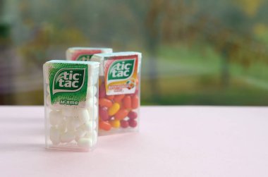 Yeşil ahşap arka planda bir sürü Tic Tac Candy paketi var. Tik tak naneli taze tadı ve taşıması kolay olduğu için popülerdir. 1968 'den beri Ferrero tarafından üretilen nane şekeri.