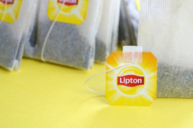 Pastel sarı yüzeyde Lipton Sarı Etiketli siyah çay poşetleri. Yaklaş. Lipton dünyaca ünlü bir çay türüdür.