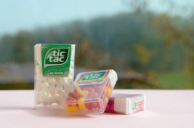 Yeşil ahşap arka planda bir sürü Tic Tac Candy paketi var. Tik tak naneli taze tadı ve taşıması kolay olduğu için popülerdir. 1968 'den beri Ferrero tarafından üretilen nane şekeri.