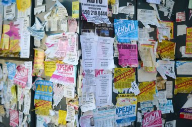 Kharkov, Ukrayna - 2 Ekim 2019: Grunge Mesaj Kurulu birçok reklamla birlikte. İnsanlar beyaz kağıda reklam ve bilgi yayıyorlar, metal çitlere asmaktansa.