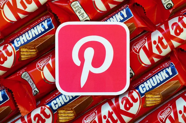 Pinterest paper logo on many Kit Kat chocolate covered wafer bars in red wrapping. Advertising chocolate product in Pinterest social network and world wide web – stockfoto