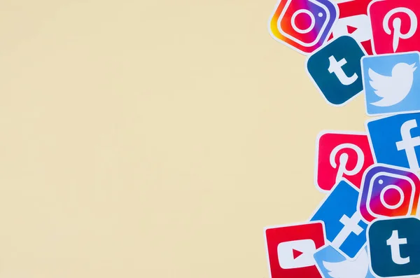 Many social network printed icons lies in pile on beige background with copy space. Facebook Instagram Pinterest Twitter Youtube Tumblr. Abstract internet background — Stock Photo, Image
