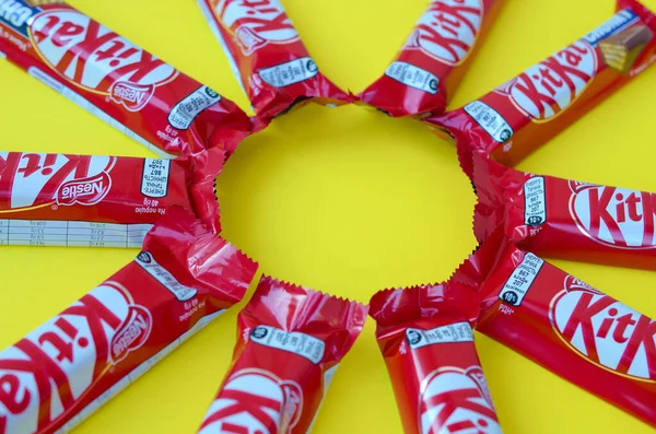 Kit Kat barras de chocolate en rojo envoltura se encuentra en el fondo amarillo. Kit kat creado por Rowntree 's de York en Reino Unido y ahora es producido globalmente por Nestle —  Fotos de Stock