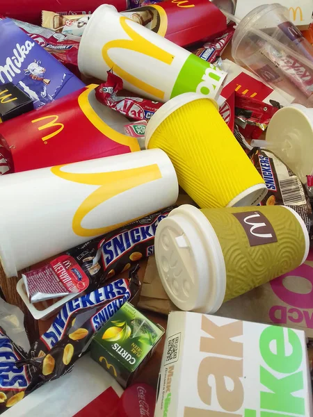 Muchos utilizan envolturas de alimentos y latas de bebidas por marcas famosas de fabricación de alimentos al azar. Basura reciclada de golosinas y bebidas gaseosas —  Fotos de Stock