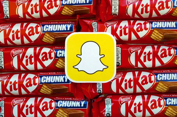 Snapchat paper logo on many Kit Kat chocolate covered wafer bars in red wrapping. Advertising chocolate product in Snapchat social network and world wide web – stockfoto