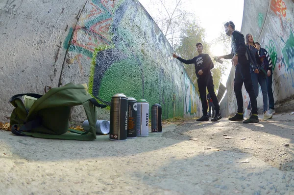 KHARKOV, UCRANIA - 19 DE OCTUBRE DE 2019: latas de spray usadas para pintar graffiti de muchas marcas de pintura al aire libre en otoño y artista en proceso de pintura —  Fotos de Stock