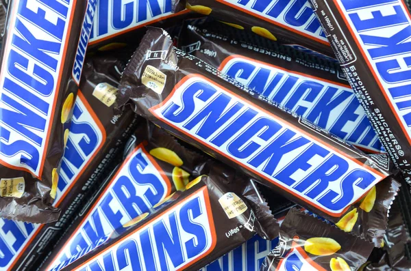 Veel Snickers chocoladerepen zijn van dichtbij opgestapeld. Snickers bars worden geproduceerd door Mars Incorporated. Snickers is gemaakt door Franklin Clarence Mars in 1930. — Stockfoto