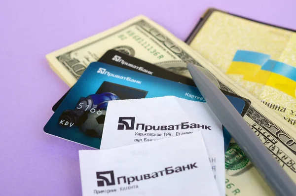 Приватбанк проверяет кредитные карты и ручку на долларовых купюрах с паспортом. ПриватБанк является главным финансовым отделом Украины, депозитарием денег в гривне — стоковое фото