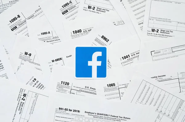 Logotipo impresso do Facebook em muitos espaços em branco formulário de imposto está na tabela de fechar. Ajuda com problemas fiscais usando internet e informações de redes sociais — Fotografia de Stock