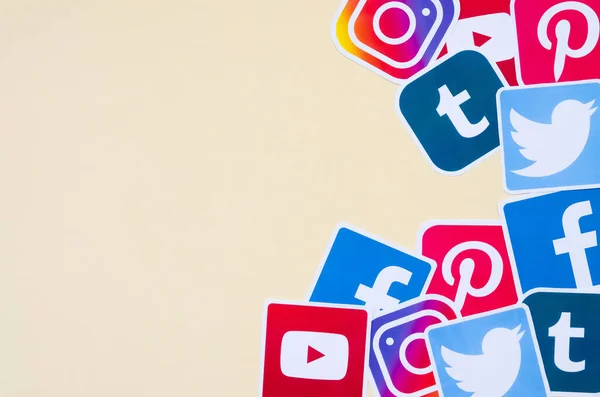 Veel sociale netwerk gedrukte pictogrammen ligt in stapel op beige achtergrond met kopieerruimte. Facebook Instagram Pinterest Twitter Youtube Tumblr. Abstracte internet achtergrond — Stockfoto
