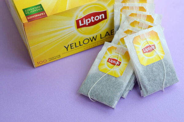 Пакет черного чая Lipton Yellow Label и чайные пакетики на поверхности пастилы крупным планом. Липтон - всемирно известный бренд чая
