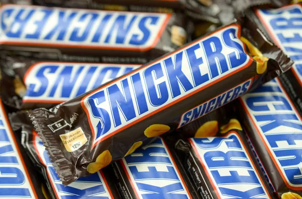 Muchas barras de chocolate Snickers apiladas de cerca. Las barras Snickers son producidas por Mars Incorporated. Snickers fue creado por Franklin Clarence Mars en 1930 —  Fotos de Stock