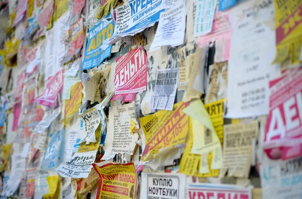 Kharkov, Ukrayna - 2 Ekim 2019: Grunge Mesaj Kurulu birçok reklamla birlikte. İnsanlar beyaz kağıda reklam ve bilgi yayıyorlar, metal çitlere asmaktansa.