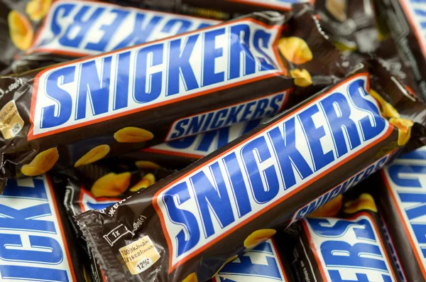 Muchas barras de chocolate Snickers apiladas de cerca. Las barras Snickers son producidas por Mars Incorporated. Snickers fue creado por Franklin Clarence Mars en 1930 — Foto de Stock