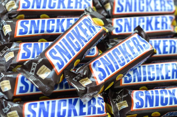 Veel Snickers chocoladerepen zijn van dichtbij opgestapeld. Snickers bars worden geproduceerd door Mars Incorporated. Snickers is gemaakt door Franklin Clarence Mars in 1930. — Stockfoto