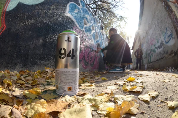 KHARKOV, UKRAINE - OUTUBRO 19, 2019: Montana mtn 94 lata de spray usado para a pintura de grafite ao ar livre em folhas de outono e artista em processo de pintura — Fotografia de Stock