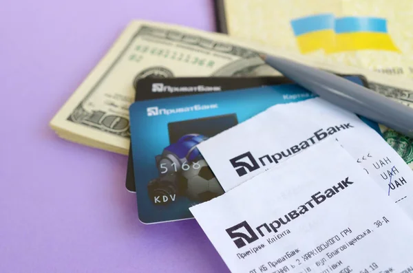 Приватбанк проверяет кредитные карты и ручку на долларовых купюрах с паспортом. ПриватБанк является главным финансовым отделом Украины, депозитарием денег в гривне — стоковое фото