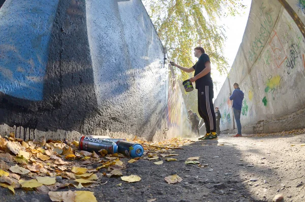 Kharkov, Ukraina - 19 oktober 2019: Dope använde sprayburkar för graffitimålning utomhus på höstlöv och konstnär i målningsprocessen — Stockfoto