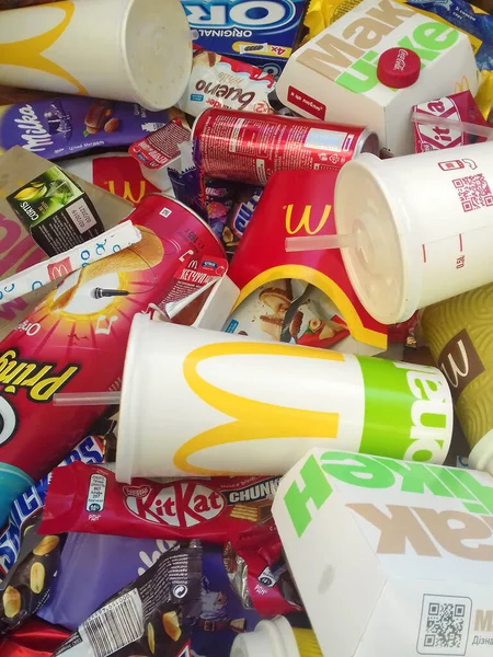 Muitos usavam embalagens de alimentos e latas de bebidas por marcas famosas de fabricação de alimentos aleatórios. Lixo reciclado de guloseimas e refrigerantes — Fotografia de Stock