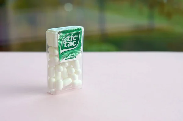 Many Tic Tac Candy packages on green wood background. Tic tac is popular due its minty fresh taste and easy to carry. Hard mints produced by Ferrero since 1968 Stock Photo