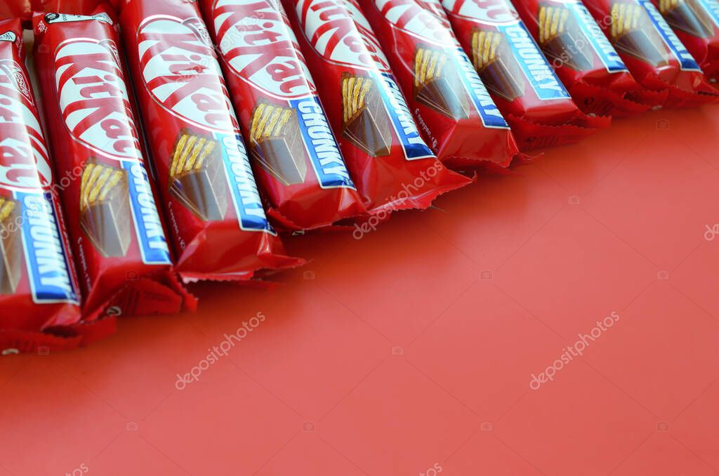 Kit Kat barras de chocolate en rojo envoltura se encuentra en el fondo amarillo es ahora