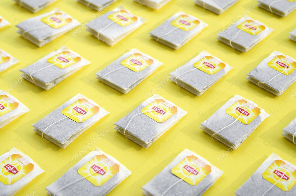 KHARKOV, UKRAINE - OCTOBER 4, 2019: Flat lay of Lipton Yellow Label black tea bags on pastel yellow surface. Lipton is a world famous brand of tea