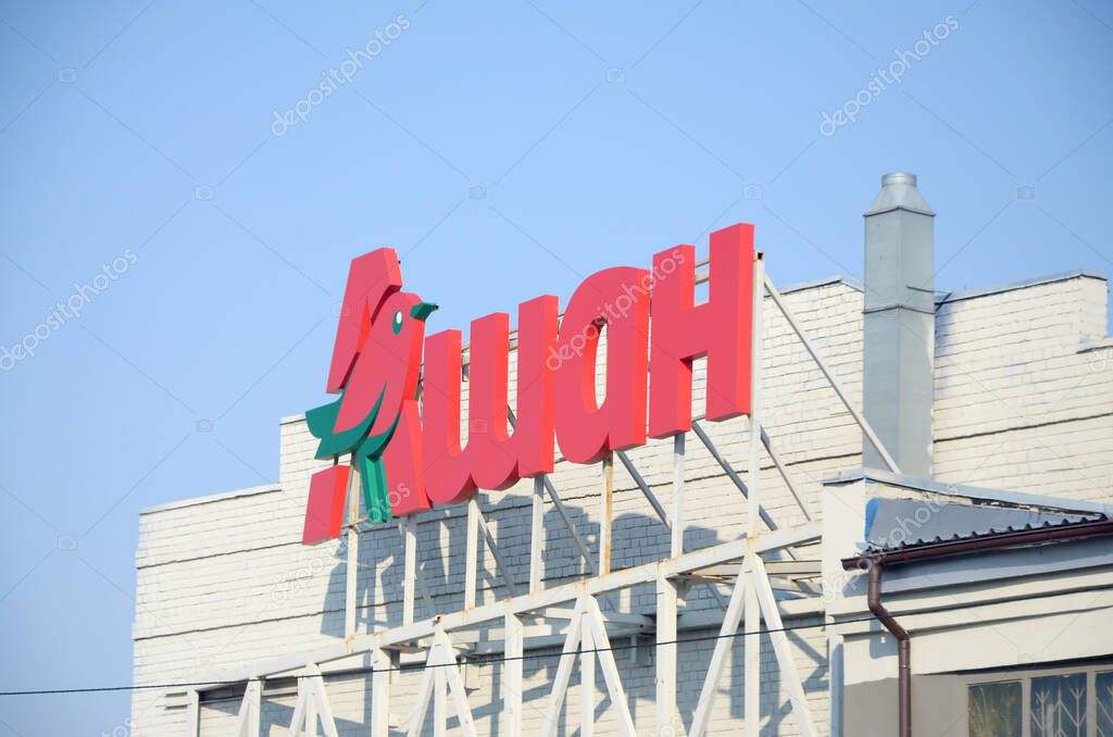 KHARKOV, UKRAINE - OCTOBER 20, 2019: Auchan supermarket logo on the building roof. Auchan is a French international retail group