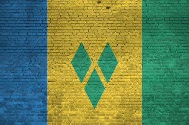 Aziz Vincent ve Grenadines bayrağı eski tuğla duvarda boya renkleriyle resmedilmiş. Büyük tuğla duvarlı arka planda desenli afiş