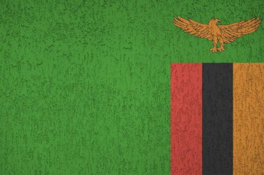 Zambiya bayrağı eski kabartma duvarda parlak boya renkleriyle resmedilmiş. Kabataslak arkaplanda desenli pankart