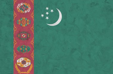 Türkmenistan bayrağı, eski kabartma duvarlara parlak boya renkleriyle resmedilmiş. Kabataslak arkaplanda desenli pankart