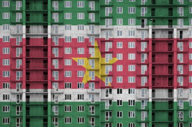 Yapım aşamasında olan çok katlı yerleşim yerlerinin renkleri ile resmedilmiş bir bayrak. Büyük tuğla duvar zemininde desenli pankart