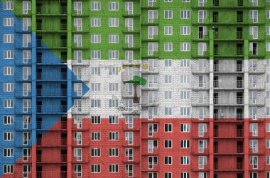 Yapım aşamasında olan çok katlı konut binasının üzerine boya renkleriyle çizilmiş Ekvator Ginesi bayrağı. Büyük tuğla duvar zemininde desenli pankart