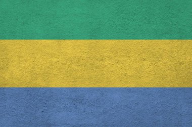 Gabon bayrağı eski kabartma duvarda parlak boya renkleriyle tasvir edilmiş. Kabataslak arkaplanda desenli pankart