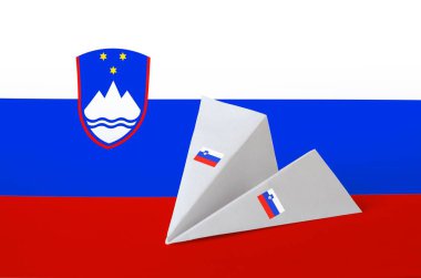 Kağıt origami uçağında Slovenya bayrağı tasvir edildi. Doğu el yapımı sanat konsepti