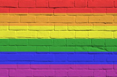 Lgbt topluluğunun bayrağı eski tuğla duvardaki boya renkleriyle tasvir edilmiş. Büyük tuğla duvarlı arka planda desenli afiş