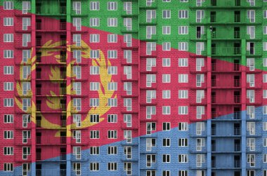 Eritre bayrağı, yapım aşamasında olan çok katlı yerleşim yerlerinin boyalarıyla resmedilmiş. Büyük tuğla duvar zemininde desenli pankart