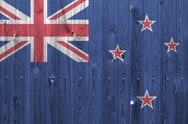 Yeni Zelanda bayrağı eski ahşap duvarda parlak boya renkleriyle tasvir edildi. Kabataslak arkaplanda desenli pankart