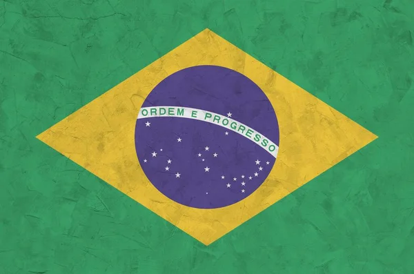 古いレリーフ石膏壁に明るい塗料の色で描かれたブラジルの旗が閉じます ざらざらとした背景に書かれた旗 — ストック写真
