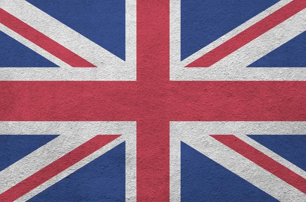 巨大的英国国旗用明亮的颜色描绘在旧的浮雕石墙上 粗糙背景的纹理横幅 — 图库照片