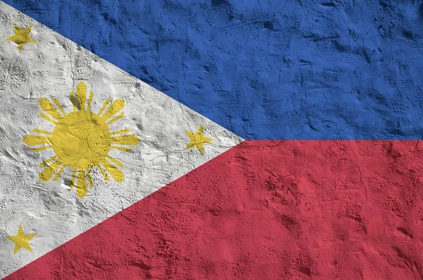 古いレリーフの石膏壁の上に明るい塗料の色で描かれたフィリピンの旗が閉じます ざらざらとした背景に書かれた旗 — ストック写真