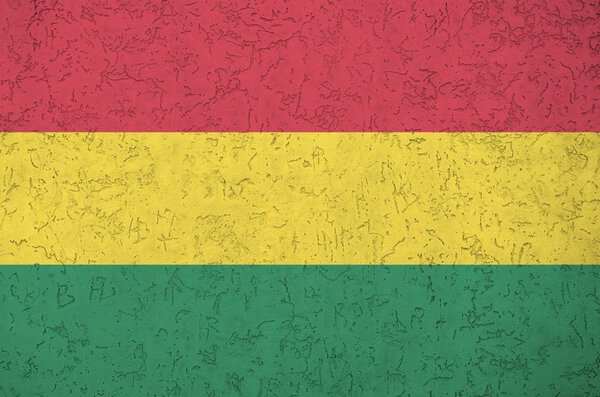 Bolivia flag depicted in bright paint colors on old relief plastering wall close up. Textured banner on rough background