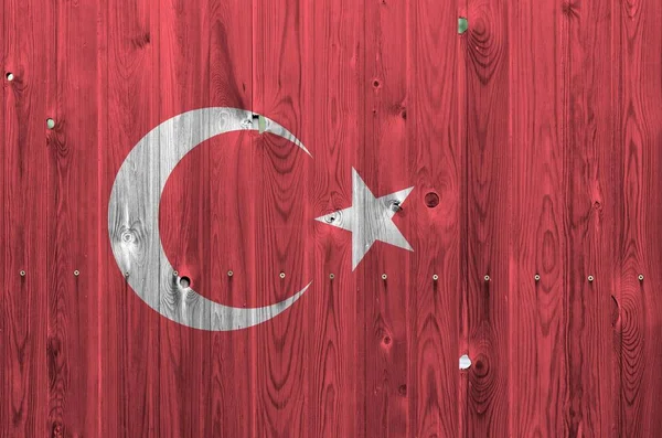 Eski ahşap duvarda parlak renkli hindi bayrağı tasvir edildi. Kabataslak arkaplanda desenli pankart