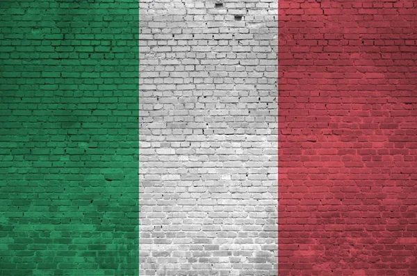 Italy flag depicted in paint colors on old brick wall close up. Textured banner on big brick wall masonry background