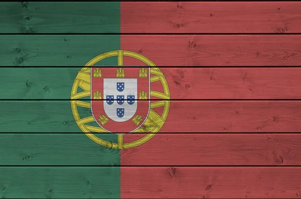 Portugal flag depicted in bright paint colors on old wooden wall close up. Textured banner on rough background